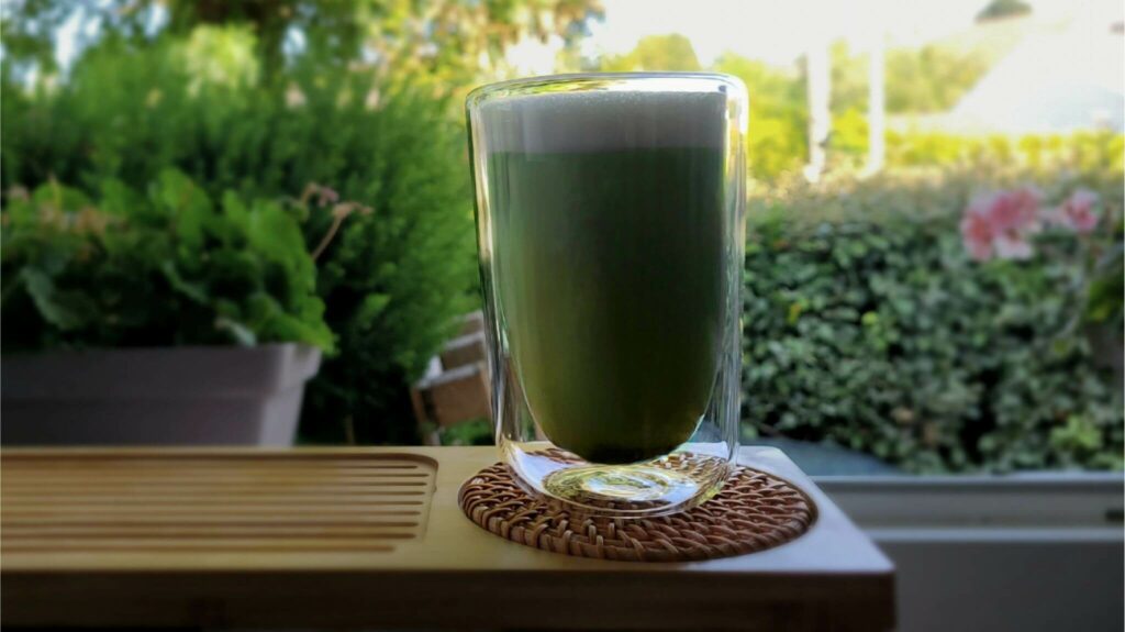matcha latte chaud dans une tasse, mousse verte crémeuse