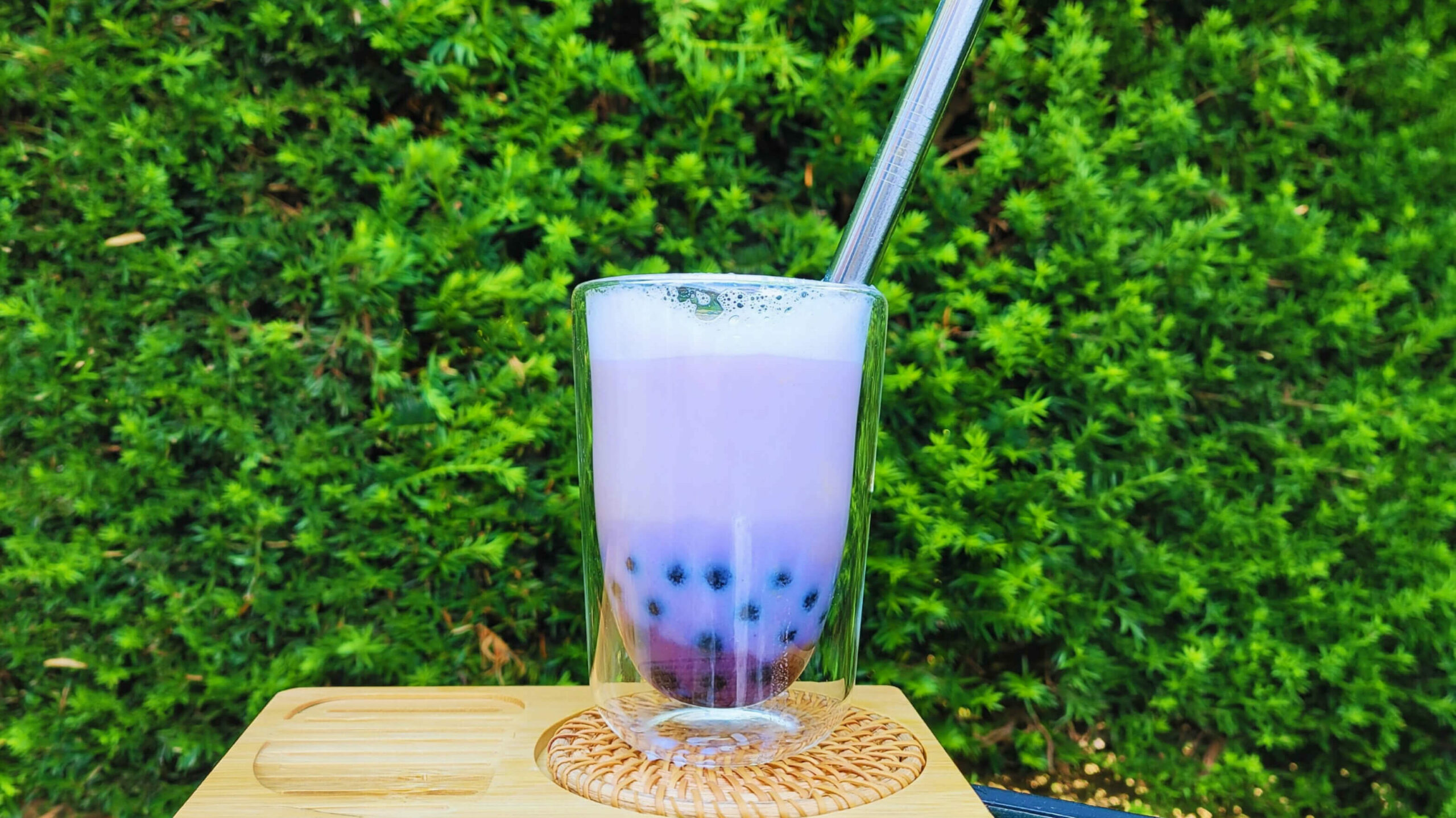Ube latte violet aux perles de tapioca dans un verre à double paroi, paille inox